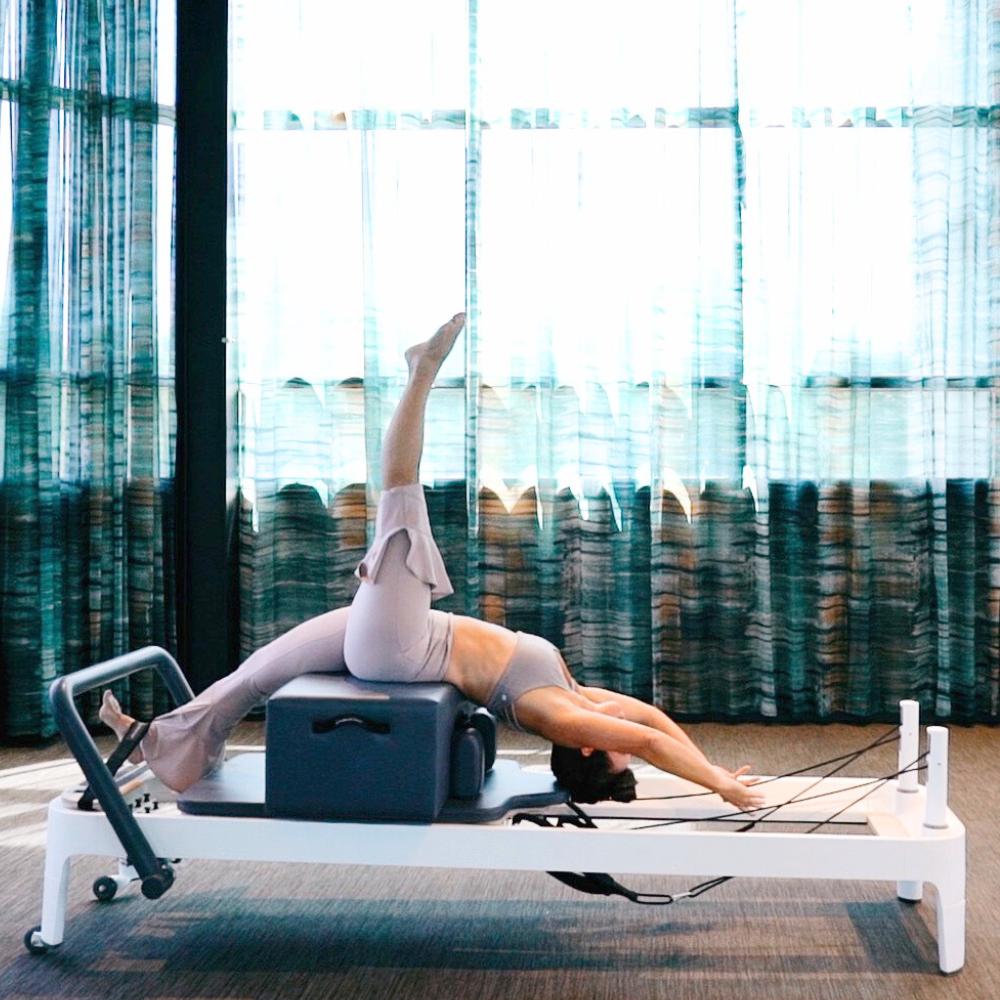 a woman practicing reformer pilates at newtown athletic club