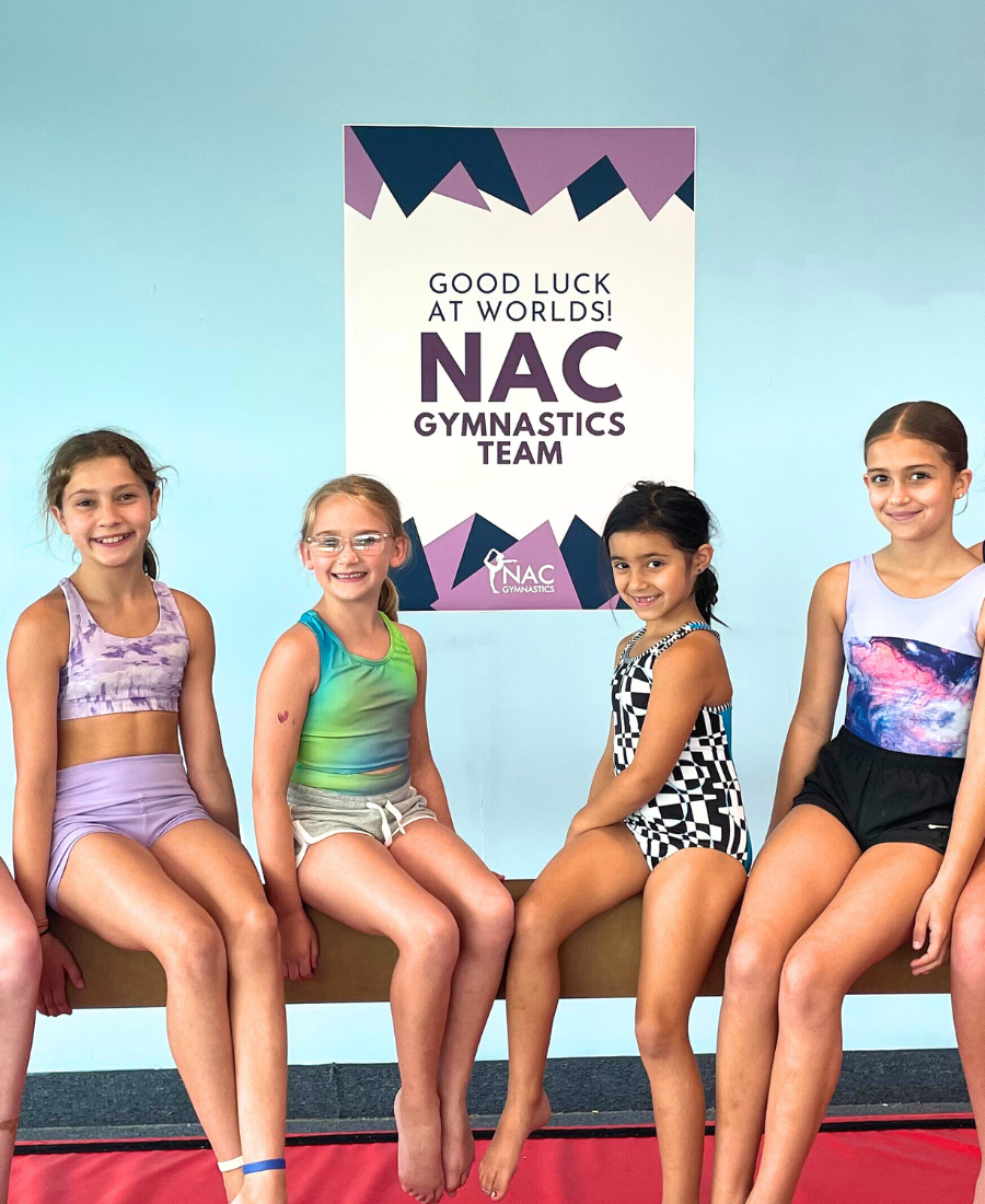 four girls excited from the newtown athletic club gymnastics team smiling because they're going to the world championships