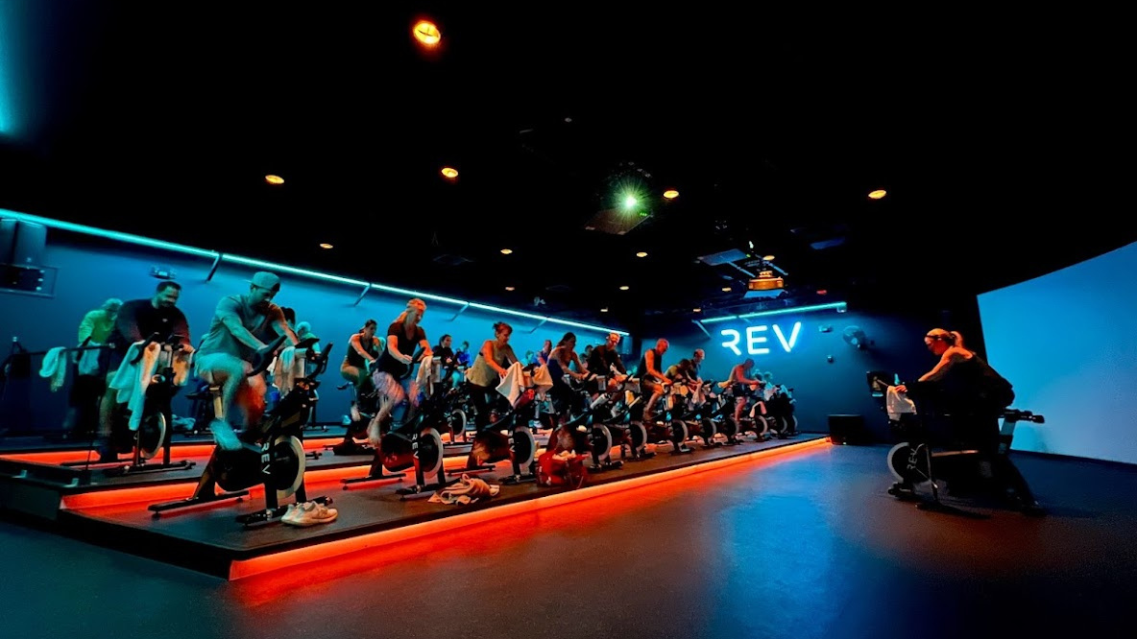 group of people participating in an indoor cycling class at newtown athletic club